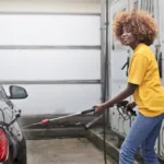 girl in yellow detailing black car
