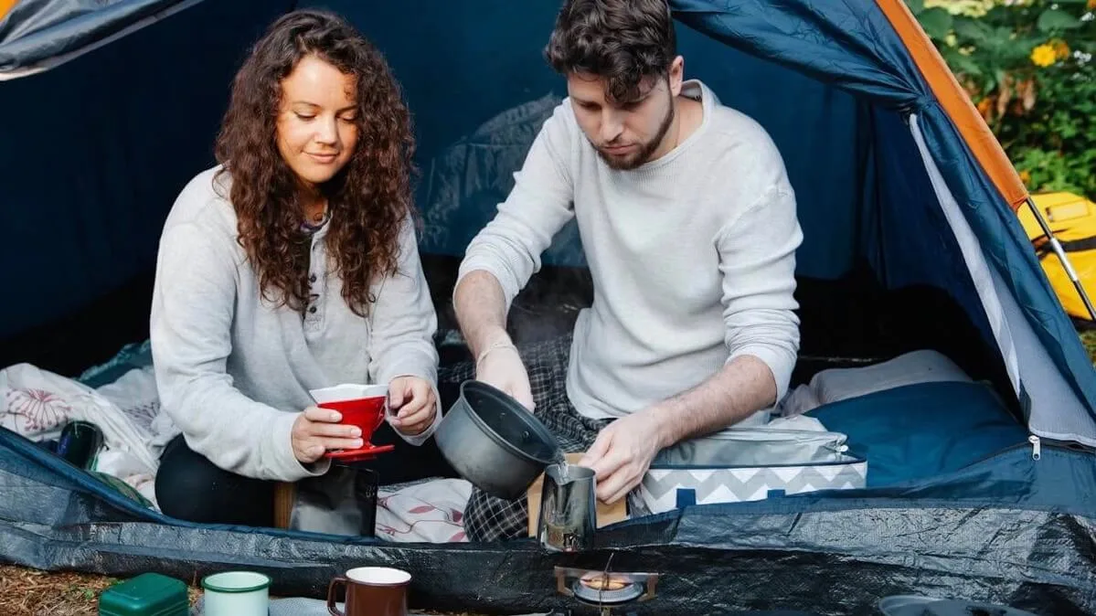 couple camping cooking with butane camping stove propane