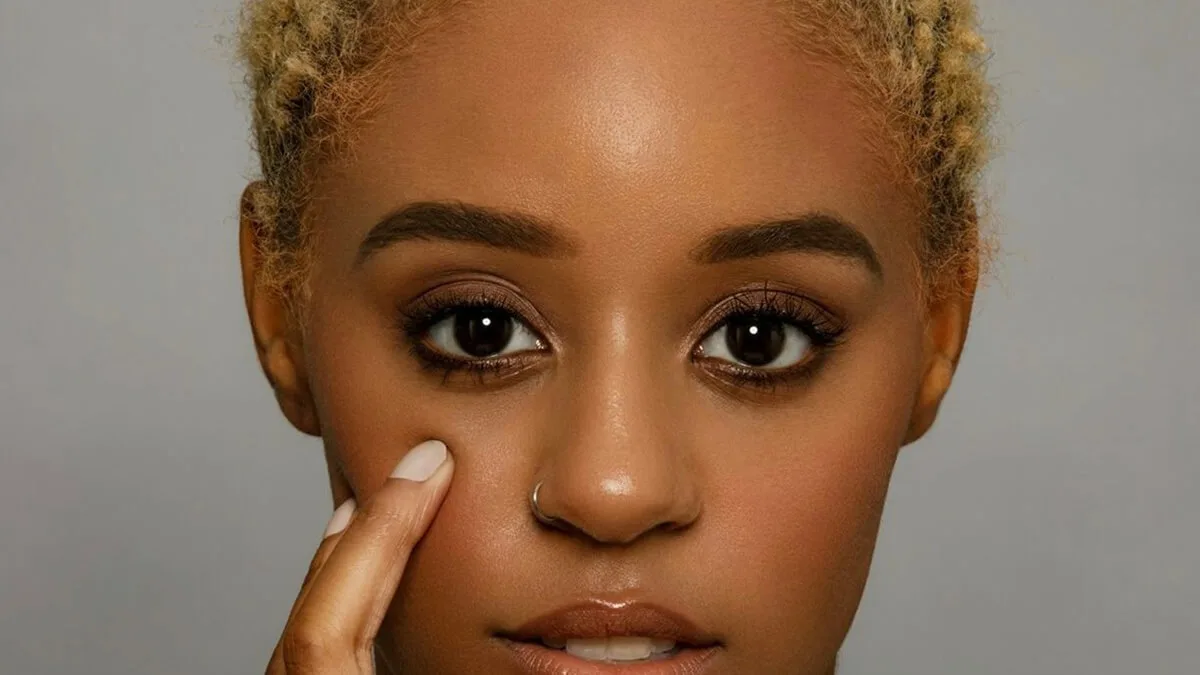 girl admires face treated with olay regenerist moisturizing anti-aging cream