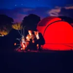 couple car camping with lantern